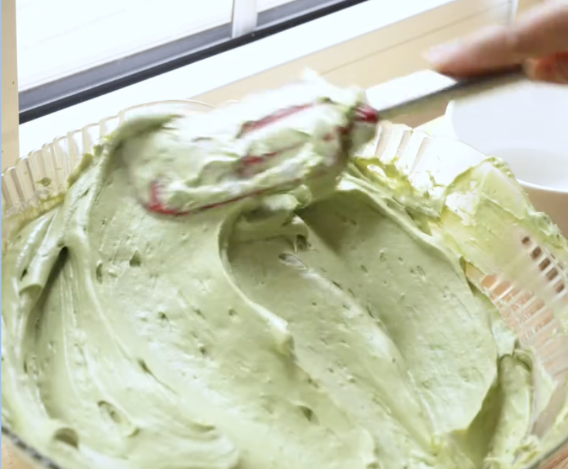 Matcha cheesecake layer being spread